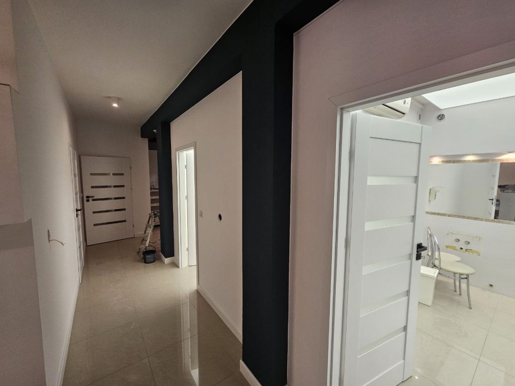 Salon masazu pomalowany na bialo z kolumnami oliwkowego koloru